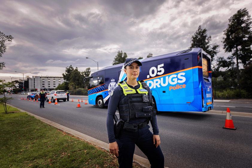 A police officer stands in front of a roadside testing station