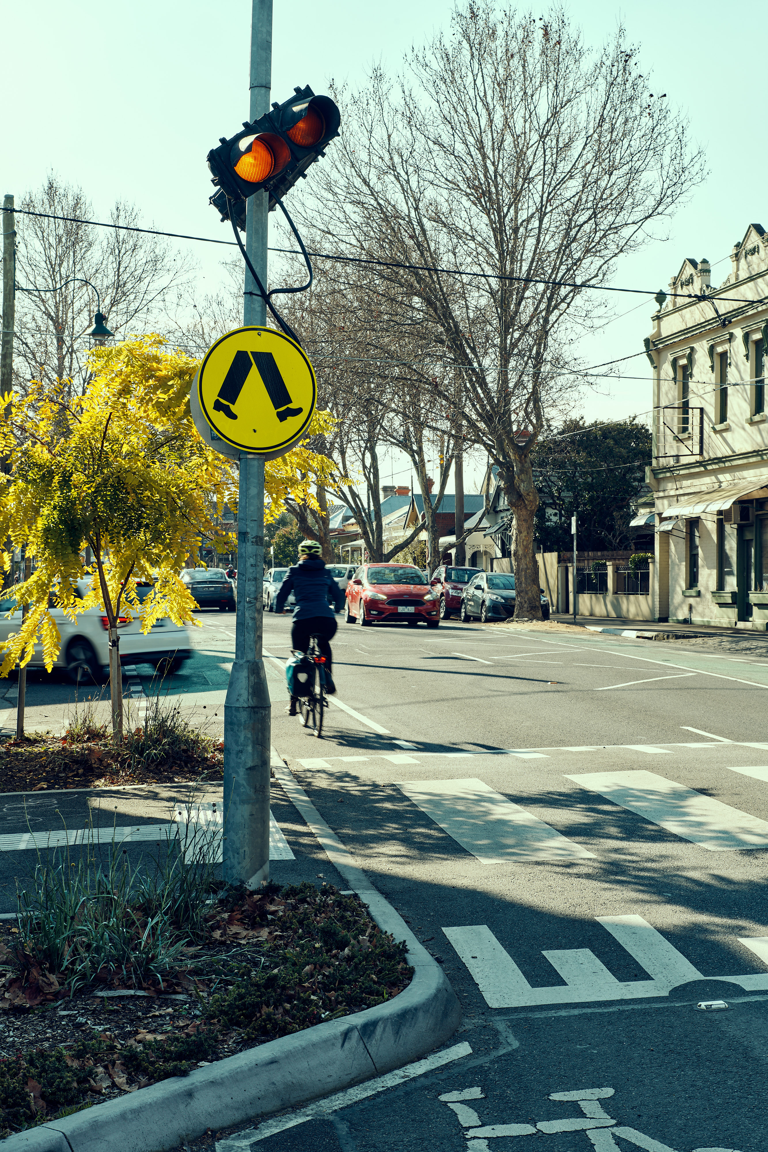 Street scene including a cyclist and pedestrian crossing