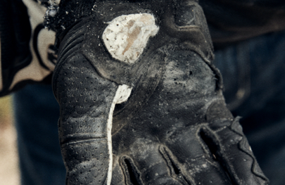 A close up of motorcycle gloves damaged after a crash