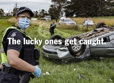 A Victoria Police officer stands at the scene of a serious car crash