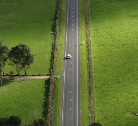 Aerial photo of a car driving down a country road