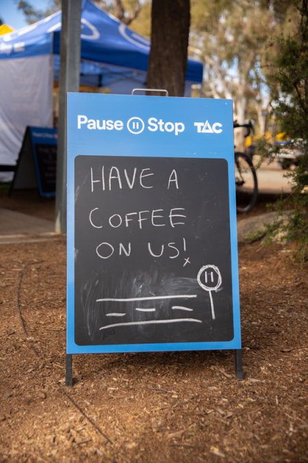 Pause stop sandwich board that reads 'Have a coffee on us' 